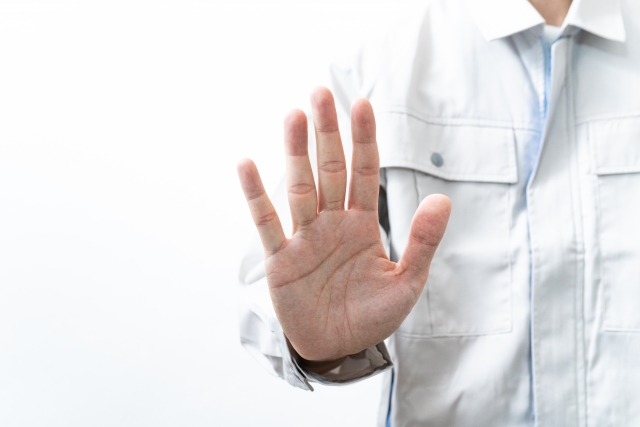 作業手を着た人が手のひらを見せている