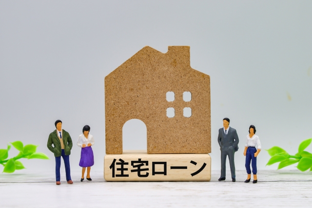 家の形をした木と4体の人形と住宅ローンという文字が書いている木がある