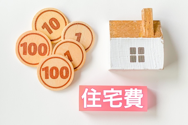 家の模型とお金と住宅費という文字の書いたものがある