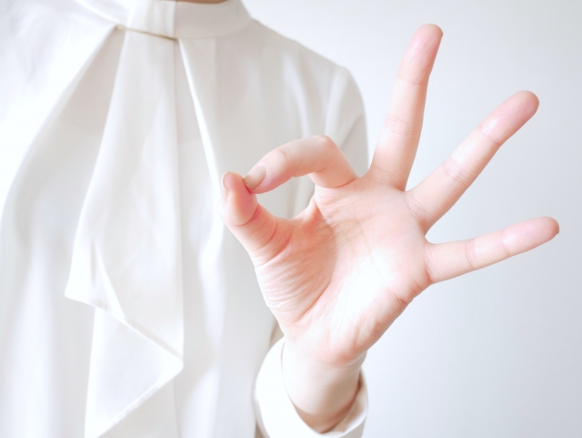 白い服を着た人が親指と人差し指をくってけている