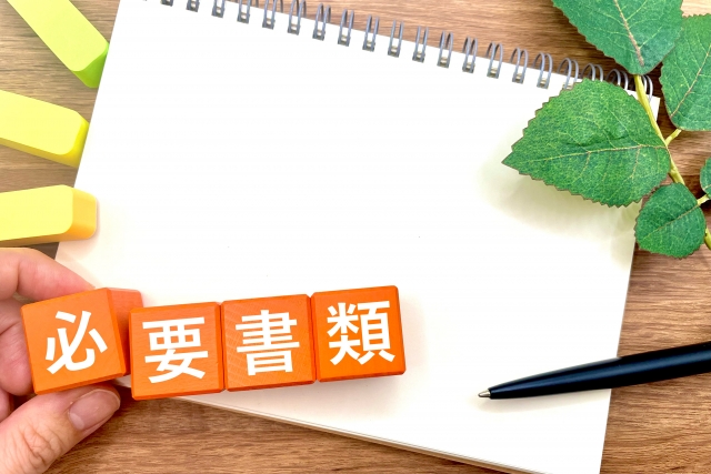 必要書類という文字の周りにノートとペンと付箋がある