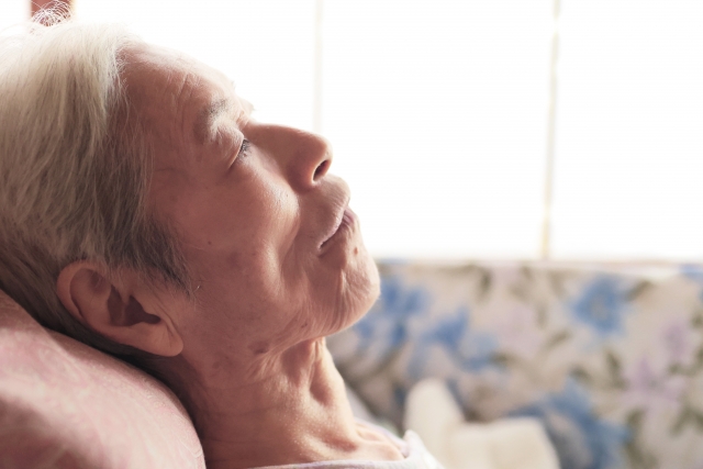 寝たきり高齢の女性の横からの写真