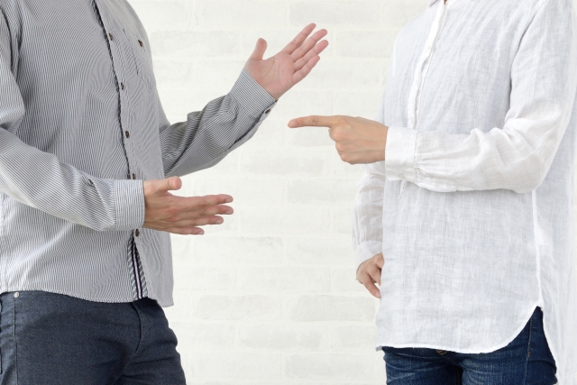 グレイ色のシャツを着た人と白色のシャツを着た人が口論をしている