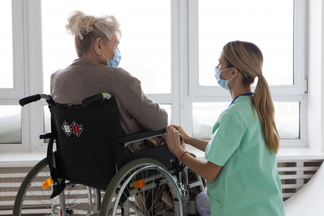 車いすにのった高齢の女性と介護している女性の後ろ姿